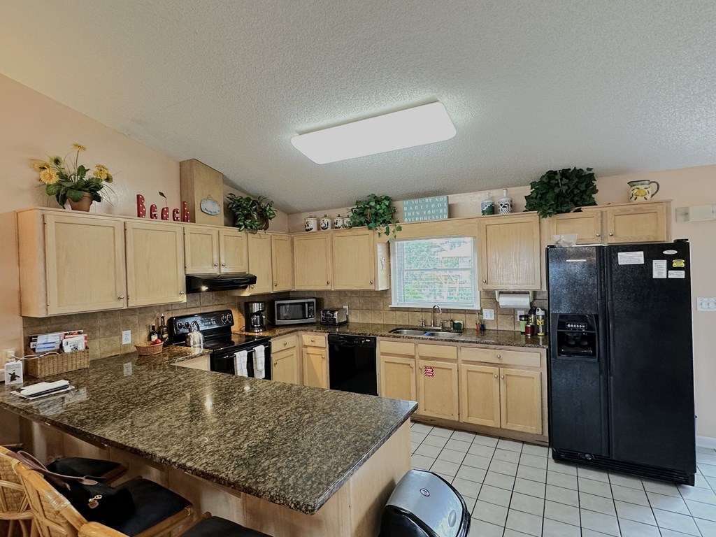 Spacious kitchen with granite countertops and tile